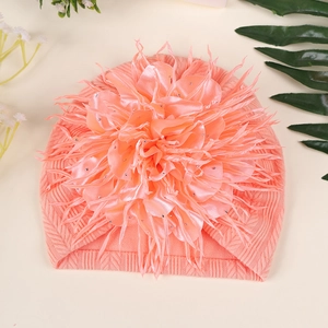 Detail einer großen rosa Satinblume mit Strasssteinen auf einer Baby Turban-Mütze
