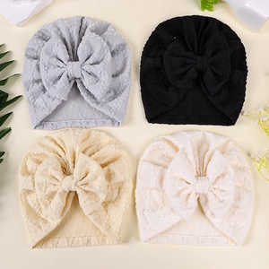Mise à plat de turbans pour bébé avec grands nœuds en gris, noir, beige et blanc pur