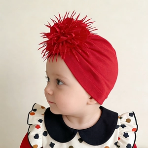 Detail of soft red newborn turban hat featuring a large 3D fabric flower on front