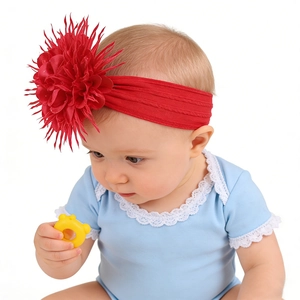 Détail d'un bébé portant un bandeau en nylon rouge vif avec une grande fleur double