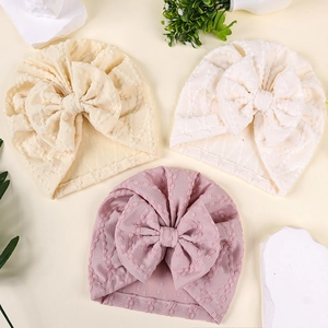 Détail de la texture gaufrée des turbans pour bébé avec de grands nœuds décoratifs