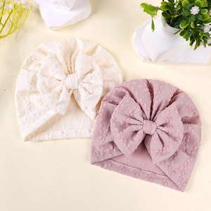 Bonnets bébé avec nœuds décoratifs en crème et violet pastel avec texture tricot