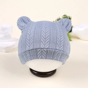Vue détaillée du bonnet en tricot bleu clair pour bébé avec oreilles d'ours et texture