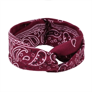 Gros plan d'un bandeau de sport paisley rouge foncé avec tissu élastique et nœud