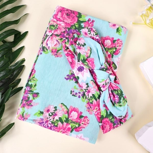 Détail d'un ensemble de l'emmaillotage pour bébé et bandeau avec motifs de roses roses