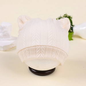 Détail du bonnet tricoté crème pour bébé avec oreilles d'ours et texture à chevrons