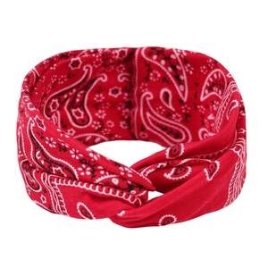 Détail d'un bandeau paisley rouge avec un nœud torsadé élégant sur fond blanc neutre