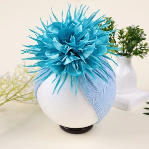 Detailaufnahme vom Baby-Turban mit türkisfarbener Satinblume und funkelnden Strasssteinen
