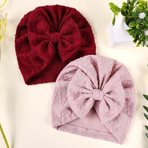 Détail de turbans pour bébé bordeaux et roses avec nœuds géants et tissu en maille texturé