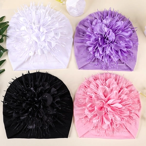 Flat lay detail showing four colors of baby turban hats with large floral accents