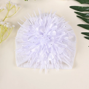 Detail der weißen Baby-Strickmütze mit großer 3D-Blume und silbernen Strasssteinen