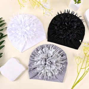 Detailed view of baby turban hats in white black and grey with sparkling floral accents