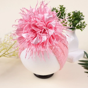 Detailansicht eines rosa Baby-Stirnbandes mit großer Satinblüte und glänzenden Pailletten