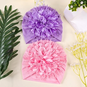 Detail of baby turban hats with large satin fabric flowers and sparkling rhinestones