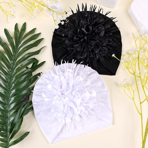 Close-up of baby turban hats featuring large silk flowers with sparkling sequins