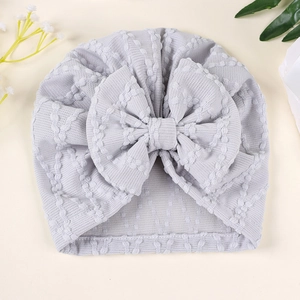 Détail du turban pour bébé gris clair avec grand nœud et texture gaufrée à vagues