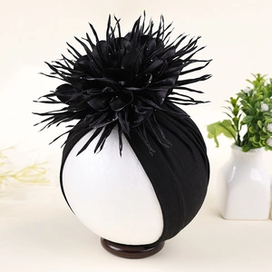 Detailed view of handmade 3D floral decoration on black baby turban hat with rhinestones