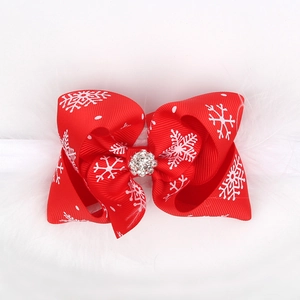 Close-up of red snowflake bow headband with white feathers and sparkling center rhinestone