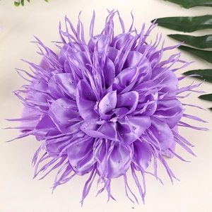 Détail d'un bandeau fleur en satin violet avec cristaux et pétales soyeux pour bébés