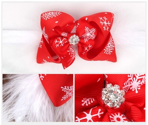 Detail view showing red snowflake bow with crystal center and fluffy white feathers