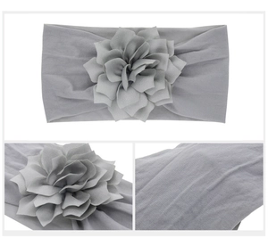 Detail of grey elastic baby headband showing layered 3D floral petals and soft knit fabric