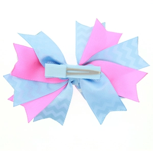 Detail view of the metal alligator clip back on a pink and blue wavy bow hair clip