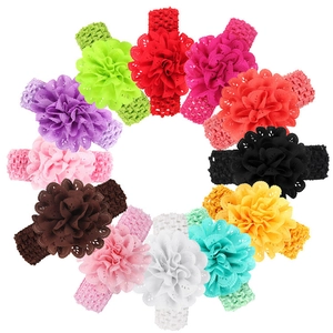 Flat lay of 12 colorful elastic baby headbands with large lace crochet flowers in a circle