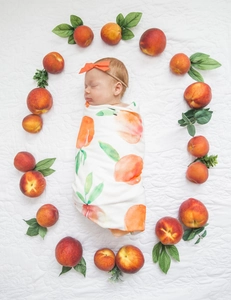 Draufsicht der weichen Baby-Puckdecke mit Pfirsich-Muster und orangefarbenem Stirnband