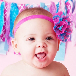 Handmade hot pink baby flower headband with light blue lace on elastic strap