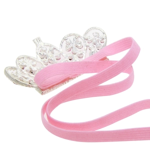 Elegante fascia corona argento per neonati con elastico rosa su sfondo bianco