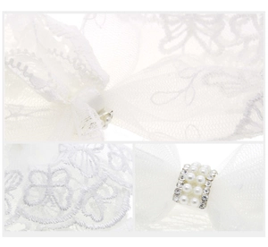 Détail d'un bandeau en dentelle blanche avec perles élégantes et strass brillants