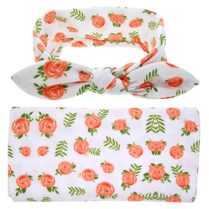Detail of baby swaddle blanket and headband set with orange rose floral pattern