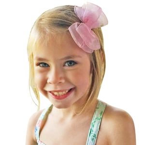 Girl wearing a large pink organza ribbon bow hair clip on blonde hair, pure white background