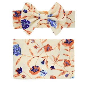 Close-up of baby swaddle and headband set with vintage orange floral print on beige fabric