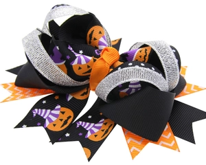 Close-up of Halloween hair clip with layered ribbons, pumpkin prints and silver sequins