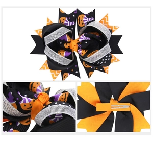 Detail of Halloween bow clip with pumpkin and wizard hat prints on grosgrain ribbons