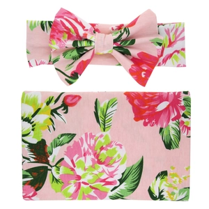 Detailed view of soft floral baby swaddle wrap with matching bow headband set