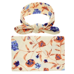 Detail of baby swaddle and headband set with vintage orange and purple floral pattern