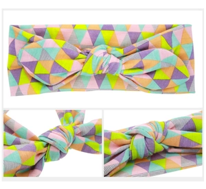 Detail of the soft elastic baby headband featuring a colorful geometric bow design