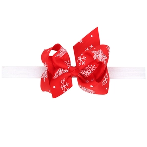Christmas baby headband with red grosgrain bow featuring white snowflakes and elastic band