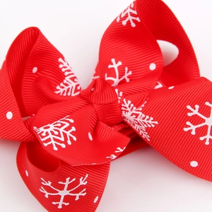 Red Christmas bow headband for babies with white snowflake and polka dot patterns