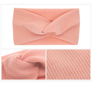 Close-up of baby ribbed knit headband featuring twist detail in soft pastel pink