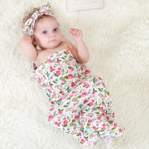 Newborn swaddle blanket and headband set with pink floral print on soft white knit fabric
