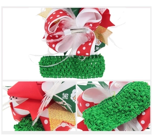 Detail view of Christmas hair bow with Merry Christmas ribbon and white feather accents