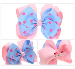 Detail view of double-layer light blue and pink polka dot bow with metal alligator hair clip