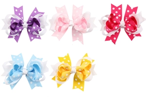 Vue détaillée de barrettes à nœuds à pois en violet, rose, rose vif, bleu et jaune