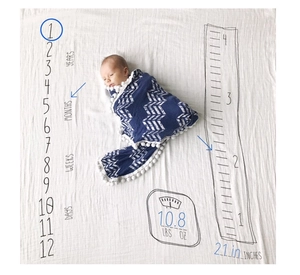 Detail of baby milestone blanket with navy wave arrow print and growth chart tracking