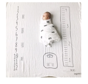 Detail view of baby milestone blanket with Batman swaddle set and measurement markers
