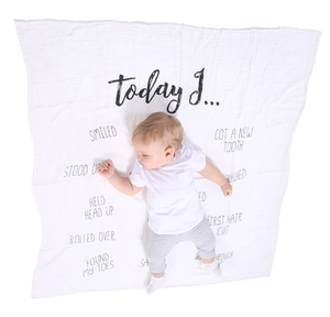 Detailed view of baby milestone blanket with soft gauze texture and growth tracking text