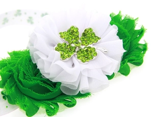 Détail de fleurs en mousseline avec trèfle en strass sur un bandeau pour bébé vert et blanc